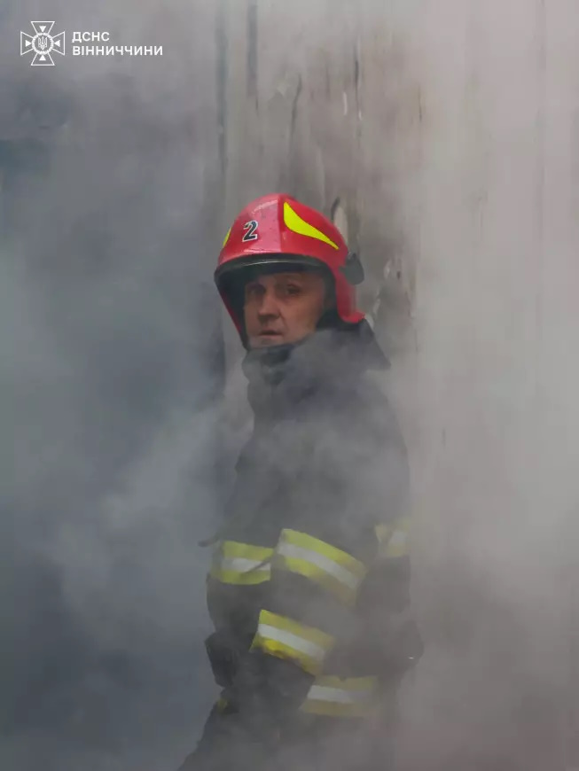 Пожежник стоїть серед диму, наслідок загоряння після атаки 28 серпня у Вінницькій області