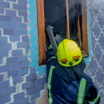 Пожежник через віно гасить вогонь у будинку на Вінниччині