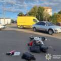 Перевенутий мопед лежить на дорозі, речі висипались, поруч знаходиться легковик та автомобіль поліції