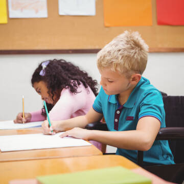 Smiling student sitting in wheelchair at the elementary school У Вінниці стартував конкурс на надання послуги супроводу під час інклюзивного навчання