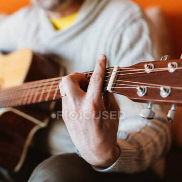 focused_256932056-stock-photo-close-man-playing-guitar-orange Математика хіта пояснює, чому деякі мелодії “застрягають” у голові
